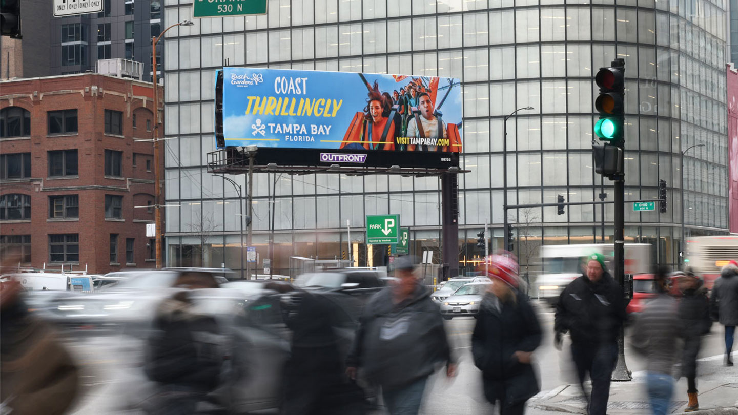 Static billboard displaying a Tampa Bay tourism campaign above a busy street